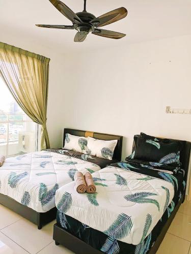 Un dormitorio con dos camas y un ventilador de techo. en Mansion One Two Bedroom Seaview 7 Pax, en George Town