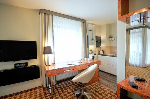 コウォブジェクにあるDOBRUK APARTAMENTY "Agnieszka" Prywatny Apartament w pięciogwiazdkowym hotelu Royal Tulip Sandのテレビとリビングルームが備わるホテルルームです。
