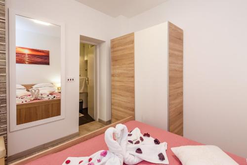 a bedroom with a bed and a mirror at Apartment Sea bass Neretva in Ploče