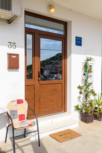 a wooden door with a window and a chair at Apartment Sea bass Neretva in Ploče