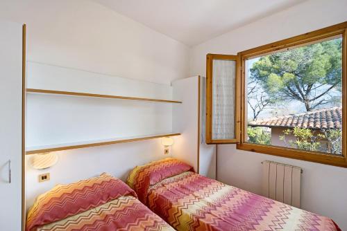 une chambre avec un lit et une fenêtre dans l'établissement Villaggio Colombo V3 comfort, à Marina dʼAndora