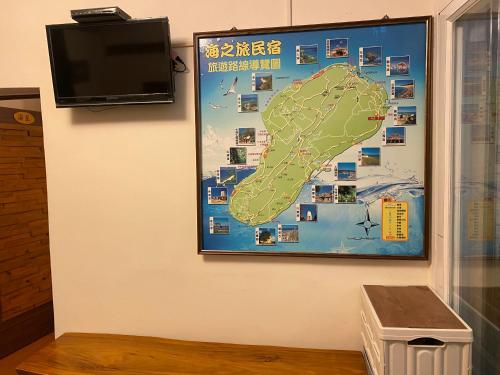 a map hanging on a wall with a tv at Sea Travel in Xiaoliuqiu