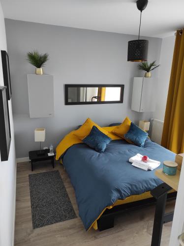 1 dormitorio con 1 cama con almohadas azules y amarillas en Chez Driss, en Crévin