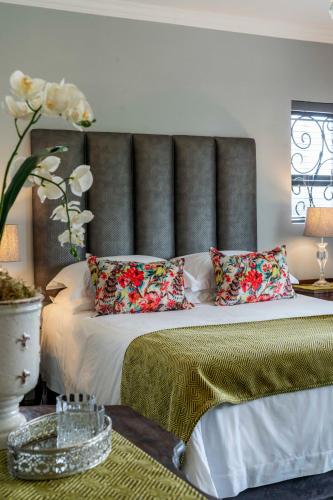 a bedroom with a bed with a large headboard at Villa Petit in Jeffreys Bay