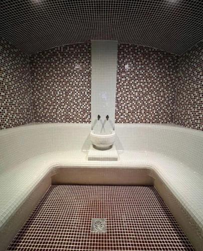 a bathroom with a tub with a sink in it at Mia's Favorite Hotel in Mavrovo