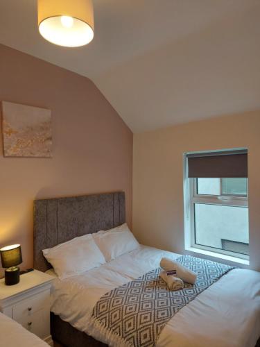 a bedroom with a bed with a lamp and a window at 4 Eyre Square Lane in Galway