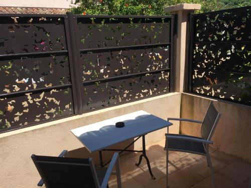 a table and two chairs on a balcony with butterflies at Chambres d'Hotes Les Amandiers in Saint-Tropez