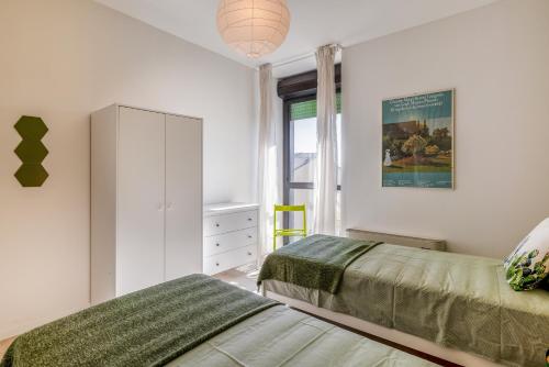 1 dormitorio con 2 camas y ventana en Family & Friends Rooms with shared bathroom en Padova