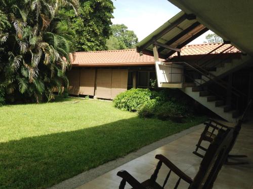 two benches sitting in front of a house at Hotel El Bramadero in Liberia