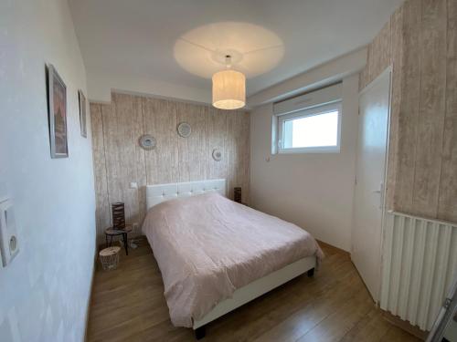 een slaapkamer met een wit bed en een raam bij PANORAMA Balcony in Pontorson
