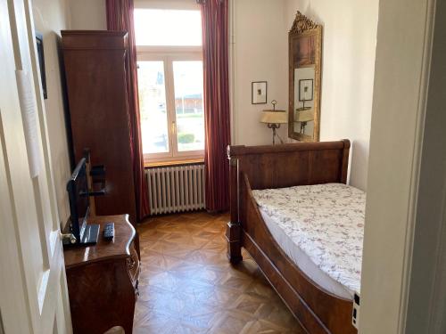 a small bedroom with a bed and a window at Zimmer Solothurn Luterbach in Luterbach
