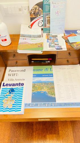 a pile of books sitting on top of a desk at Villa Arancia Quiet, Central, Parking and Air Conditioning in Levanto