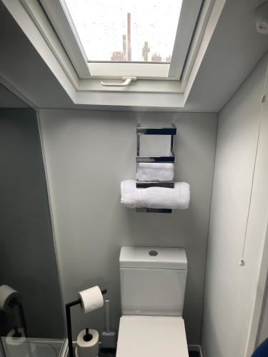 a bathroom with a toilet with a skylight at Abbey Court Guest House in Carlisle