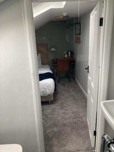 a bedroom with a bed and a desk in a room at Abbey Court Guest House in Carlisle