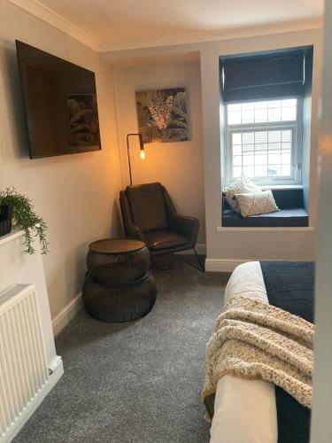 a living room with a couch and a chair and a window at Abbey Court Guest House in Carlisle