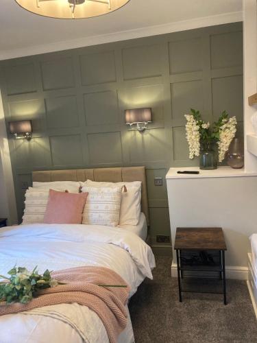 a bedroom with a green wall with a bed and a table at Abbey Court Guest House in Carlisle