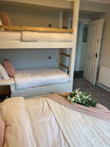 a bedroom with two bunk beds with flowers on the floor at Abbey Court Guest House in Carlisle