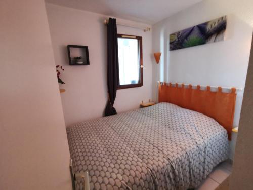 une petite chambre avec un lit et une fenêtre dans l'établissement Appartement Marina Soleil Bleu, au Barcarès