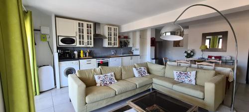 a living room with a couch and a kitchen at La salamandre in Venterol