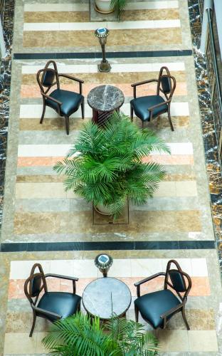 a group of chairs and tables and a plant at Weston Hotel in Nairobi
