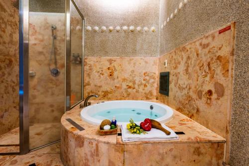 a large bathroom with a tub with a shower at Liti Motel in Taichung