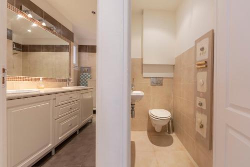 une salle de bain blanche avec des toilettes et un lavabo dans l'établissement Robert Soleau bright design flat center of Antibes, à Antibes