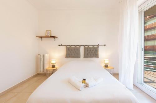 une chambre avec un grand lit blanc avec deux lampes dans l'établissement Robert Soleau bright design flat center of Antibes, à Antibes