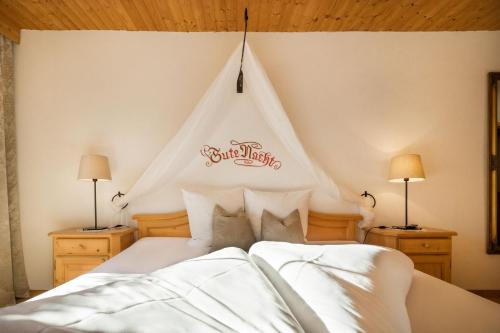 a bedroom with a white bed with a tent at Das Krumerhaus in Aschau
