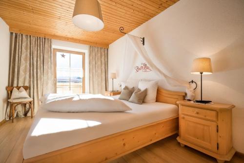 um quarto com uma grande cama branca e uma janela em Das Krumerhaus em Aschau