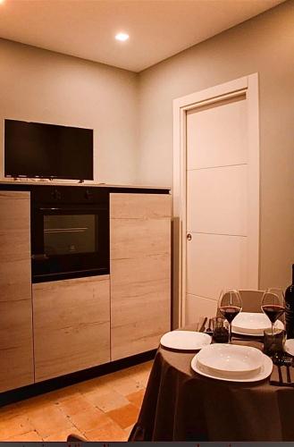 a room with a table with chairs and a television at Il Campanile Premium B&b in Altamura