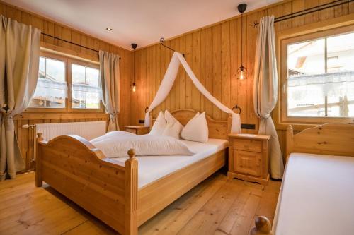 a bedroom with a bed with a canopy at Das Krumerhaus in Aschau