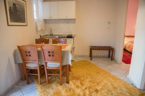 a kitchen with a table and chairs and a kitchen with a bed at ΞΕΝΟΔΟΧΕΙΟ ΠΑΠΑΝΑΓΙΩΤΟΥ in Neraïdochóri