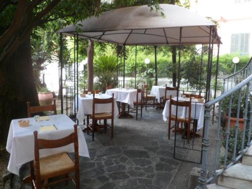 a patio area with tables, chairs and umbrellas at Hotel Liberty in Sanremo