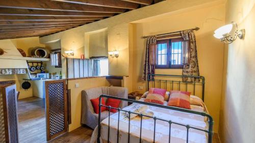 a small room with a bed and a living room at Molino Los Justos - Cocineta Algarinejo by Ruralidays in Algarinejo