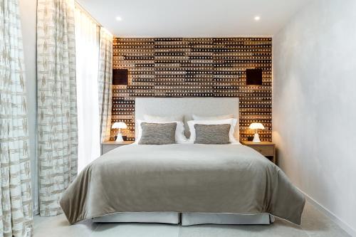 1 dormitorio con 1 cama grande y pared de ladrillo en Villa Cosy, hotel & spa, en Saint-Tropez