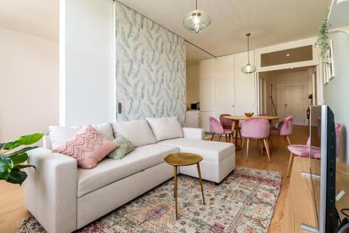 a living room with a white couch and a table at Santa Luzia Views - Modern City Centre Apartment with Iconic Views in Viana do Castelo