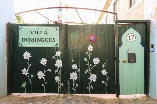 a green fence with flowers painted on it at Villa Domingues in Lisbon