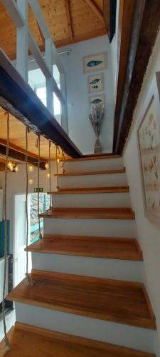 a staircase in a house with wooden ceilings at Madalena Beach Tiny House in Ponta do Sol