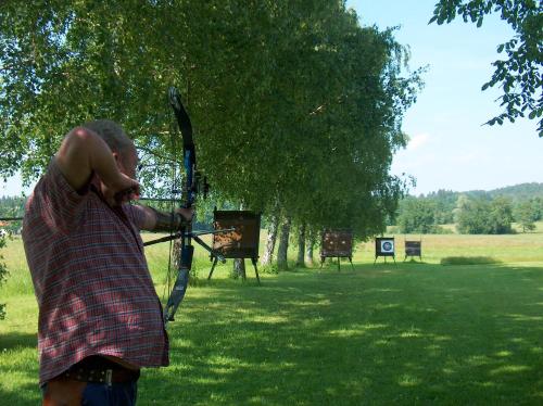 a man holding a bow and arrow in a park at Schlossberghof Marzoll in Bad Reichenhall