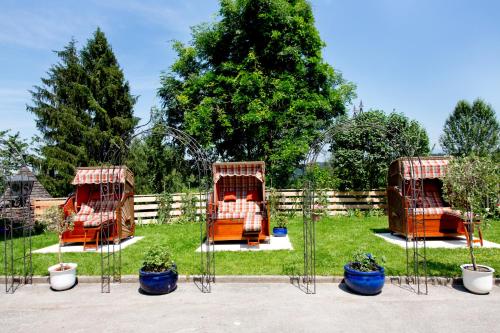 three orange chairs in a yard next to a fence at Schlossberghof Marzoll in Bad Reichenhall