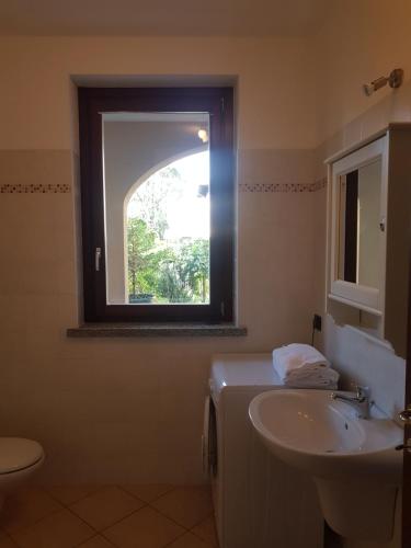 La salle de bains est pourvue d'un lavabo et d'une fenêtre. dans l'établissement Apartment Lake Maggiore - Elisa, à Maccagno Inferiore