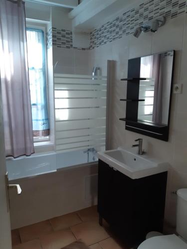 a bathroom with a sink and a tub and a toilet at A la Terrasse coeur Honfleur in Honfleur