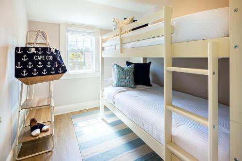 Zimmer mit Etagenbett und 2 Etagenbetten in der Unterkunft Cape Harbor Cottage in West Yarmouth