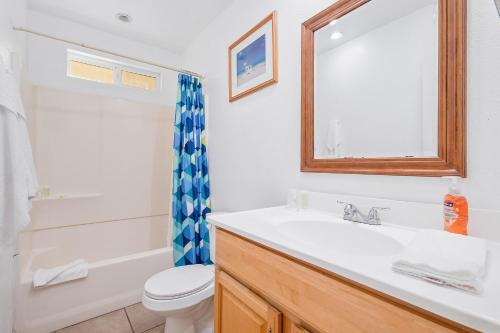 a bathroom with a sink and a toilet and a mirror at Mike's Place at the Beach in San Diego
