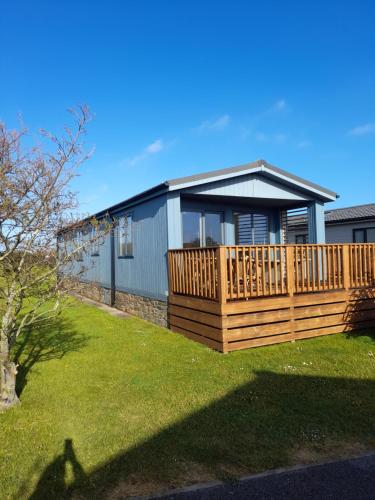 een huis met een groot houten terras in een tuin bij Midships Lodge in Salcombe