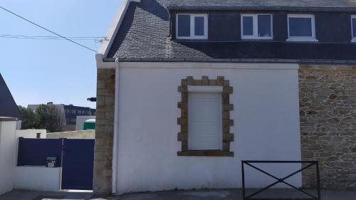 ein weißes Haus mit einem Seitenfenster in der Unterkunft Maison rénovée avec jardin proche grande plage in Quiberon