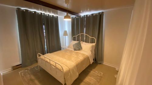 1 dormitorio con 1 cama en una habitación con cortinas en Le Milka II, en Longueuil