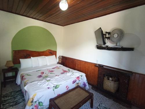 Pousada Da Santina في فيسكوندي دي ماوا: غرفة نوم مع سرير وتلفزيون على الحائط