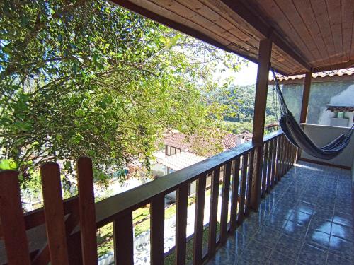 a porch with a hammock on a house at Pousada Da Santina in Visconde De Maua