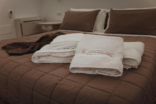 a group of towels sitting on top of a bed at Il Campanile Premium B&b in Altamura
